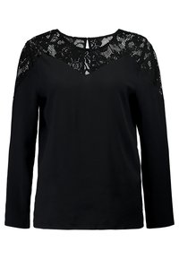 Svart långärmad blus med spetsdetaljer på axlarna och övre bröst, med en liten nyckelhålsöppning fram.