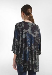 Schwarzes Blumenoberteil mit lockerem Schnitt, Kimono-Ärmeln und einer Mischung aus Dunkelblau- und Grautönen mit abstrakten Mustern. Weicher, leichter Stoff.