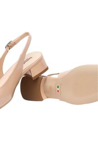 Décolleté beige in pelle verniciata con tacco basso a blocco e suola in gomma testurizzata. Nome del modello stampato in nero sulla soletta interna.