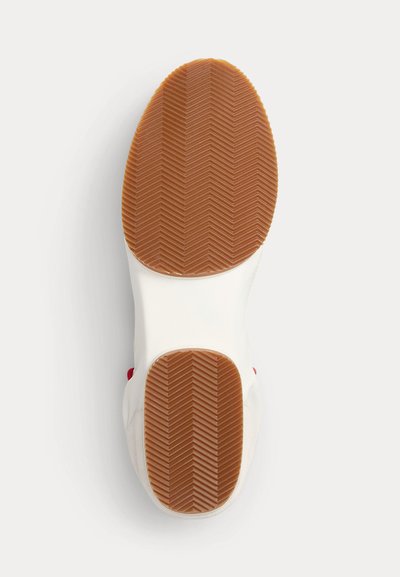 Witte schoenenzool met een bruine rubberen zool met een visgraatmotief op de teen- en hielgedeeltes tegen een witte achtergrond.