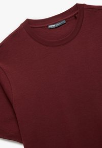 Bordowy t-shirt z okrągłym dekoltem, wykonany z miękkiej bawełny. Charakteryzuje się regularnym krojem i krótkimi rękawami. Gładka faktura z minimalnymi detalami szwów.