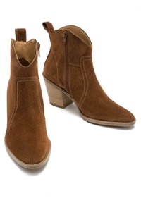 Brązowe zamszowe botki za kostkę z szpiczastym noskiem i blokowym obcasem, ozdobione dekoracyjnym haftem i bocznym zapięciem na zamek.