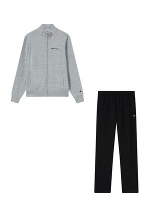 Grauer Sweatshirt mit Reißverschluss und Champion-Logo auf Brust und Ärmel, kombiniert mit schwarzen Hosen mit elastischem Bund und kleinem Champion-Logo am Oberschenkel.