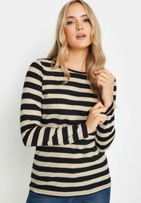 Raidallinen pitkähihainen paita vaaleassa ja mustassa. Ominaisuuksiin kuuluu pyöreä pääntie ja istuva siluetti. Pehmeä kangas ja kontrastoivat pystysuorat raidat.