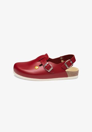 Red leather clogs with an open back, adjustable silver buckles, and a cork footbed. Smooth texture with a rounded toe and minimal detailing.