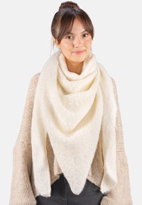 Écharpe triangulaire couleur crème faite d'un tissu doux et texturé, drapée lâchement autour du cou, avec une apparence lisse et chaleureuse.