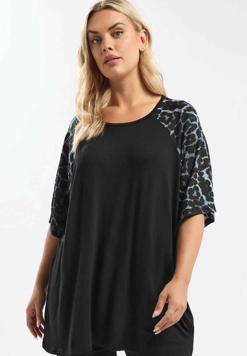 Schwarze Tunika mit Ärmeln im Leopardenprint. Weicher Stoff, lockere Passform, runder Ausschnitt und schulterfreies Design. Kurze Ärmel, lässiger Stil.