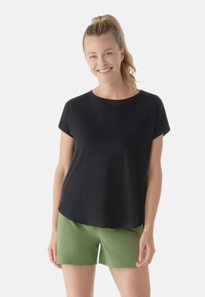 Black short-sleeve top made of smooth fabric with a rounded neckline, paired with green shorts featuring side pockets and a fitted design.