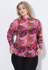 Top floreale rosa trasparente con maniche lunghe, caratterizzato da un collo alto e un orlo scallop. Accentuato da vibranti motivi floreali rossi e verdi.