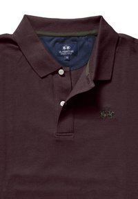 Vinröd pikétröja med knäppt krage, texturerat tyg, grön detalj inuti kragen, broderad logotyp i grönt på bröstet, storlek M.