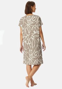 Vestido de manga corta, hasta la rodilla, en color beige con un patrón floral abstracto blanco. Confeccionado en un material suave y liso. Diseño simple y relajado.