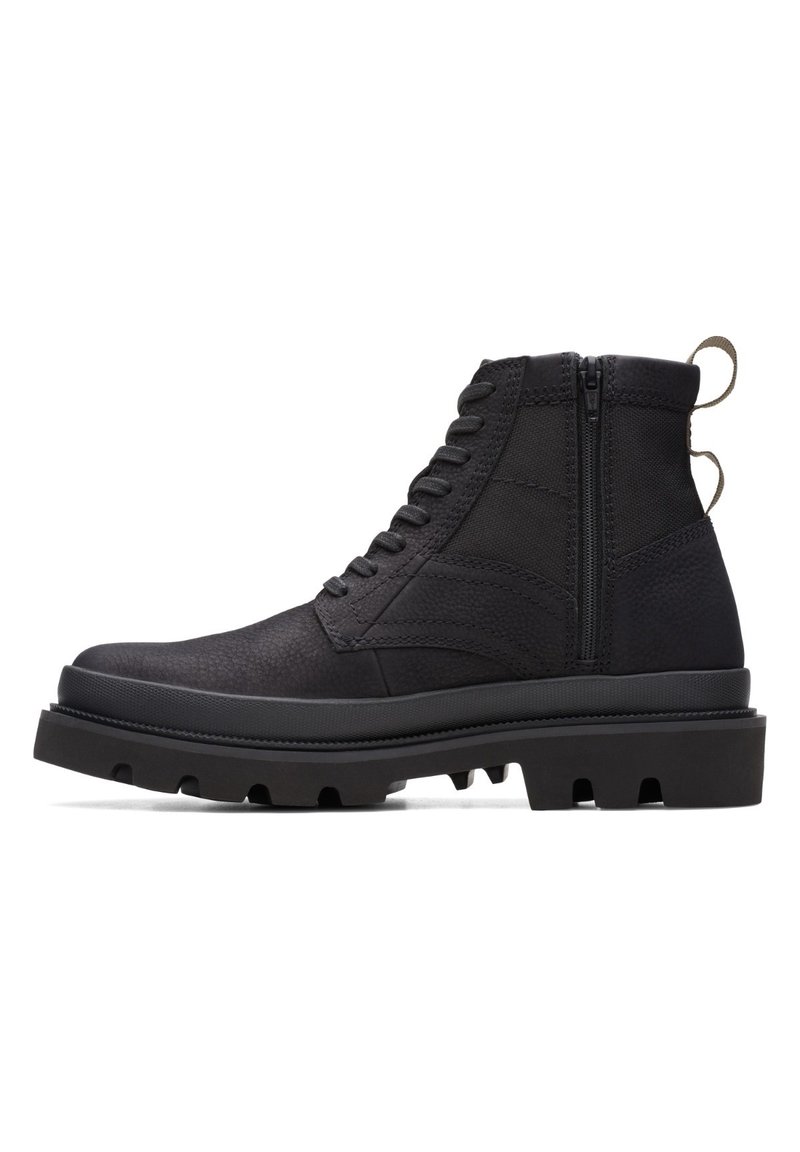 Botas de tobillo negras con parte superior texturizada, cierre de cordones y cremallera lateral. Suela de goma gruesa con tacos definidos para mayor tracción.