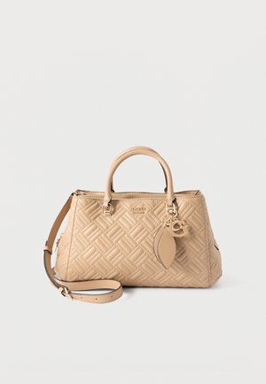 Sac à main matelassé beige avec doubles poignées, bandoulière amovible et breloque dorée avec une feuille et la lettre "G".