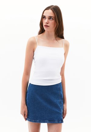 White ribbed tank top with thin straps paired with a blue denim mini skirt featuring visible stitching and a straight hem.