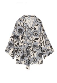 Robe in stile kimono floreale color crema con motivi di fiori neri e blu. Presenta maniche ampie e una chiusura con legatura in vita. Tessuto morbido.