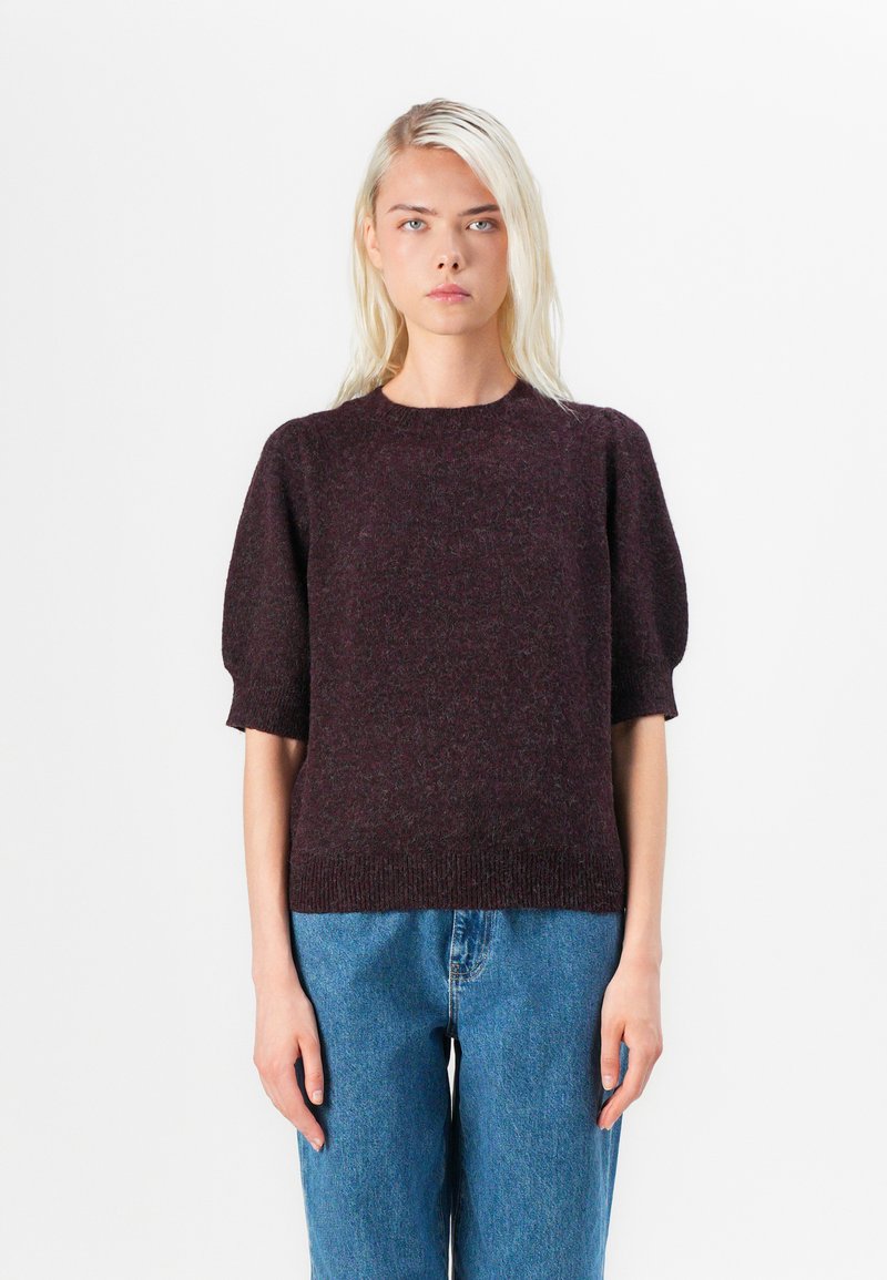 Burgundy knit sweater with short puff sleeves, textured fabric, crew neckline, and ribbed hem, paired with light blue denim jeans.