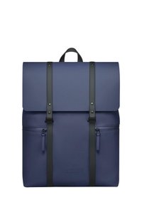 Marinblå ryggsäck med vikbar topp, svarta axelremmar och en framficka med dragkedja. Tillverkad av glattt material, med logotyp prägling på framsidan.