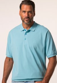 Ljusblå kortärmad polo t-shirt i mjukt tyg, med en klassisk krage, tre knappar och en prägling av logotypen på bröstet.