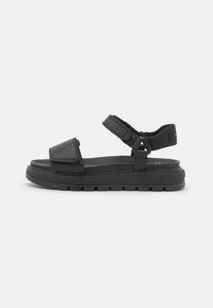 Zwarte open teen sandaal met verstelbare klittenbandsluitingen, gewatteerde zool en robuust profiel voor extra grip en comfort.