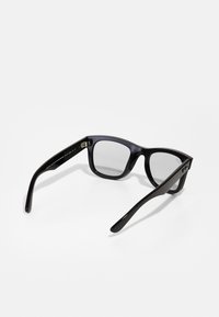 Ochelari de soare din acetat negru cu rame pătrate, lentile gri și brate subțiri. Dispune de accesorii metalice pe balamale.