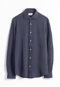 Camisa azul marino de manga larga hecha de tela suave, con cuello abotonado, cinco botones y dobladillo curvo. Logo sutil en el pecho.