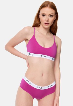 Roze katoenen crop top en bijpassende onderbroek met een contrasterende witte tailleband met zwarte letters. Soepele textuur, eenvoudig ontwerp.