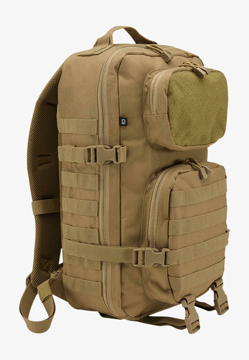 Sac à dos tactique couleur sable avec plusieurs compartiments zippés, sangles ajustables et sangles MOLLE pour fixations modulaires.