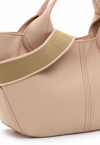 Borsa tote in pelle rosa chiaro con superficie testurizzata, dotata di una tracolla in nylon beige e dettagli di cucitura visibili. Forma curvata con cuciture laterali.