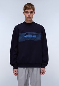 Marineblauwe sweatshirt met lange mouwen. Bevat een blauw grafisch ontwerp met de tekst "NAPAPIJRI" op de borst. Ribgebreide ronde hals en manchetten.