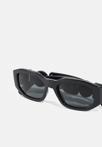 Black rectangular sunglasses with angular frames and dark lenses. Made of plastic with a smooth texture and metallic accents on the arms.