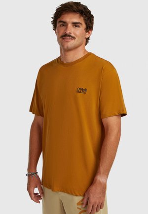 Korte mouw, mosterdkleurig t-shirt gemaakt van zachte stof. Heeft een klein zwart logo op de borst en een ontspannen pasvorm.