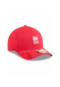 Rote Baseballkappe mit runder Krone, flachem Schild und strukturiertem Stoff. Mit einem quadratischen Aufnäher, der das "Kansas City Chiefs"-Logo zeigt.