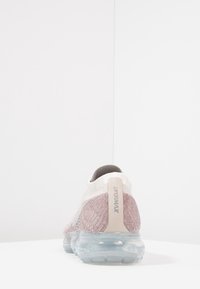 Sportschoen met een gebreide bovenkant in lichtroze en grijs, voorzien van een transparante luchtgeventileerde zool en een gevoerde kraag. Merkennaam op de hiel.