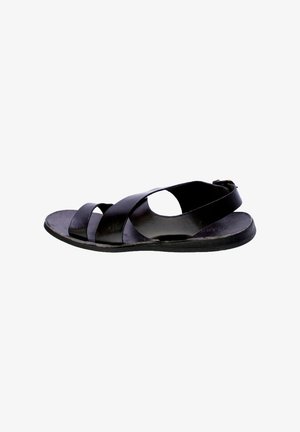 Sandal in pelle nera con cinturini incrociati, lati aperti e suola piatta. Presenta un cinturino posteriore per il supporto e una finitura liscia.
