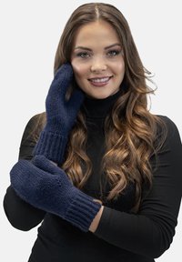 Tengerészkék kötött kesztyű ribbed mandzsettával. Vastag anyagból készült, laza szabású, texturált mintákkal és hüvelykujjal a mozgékonyság érdekében.