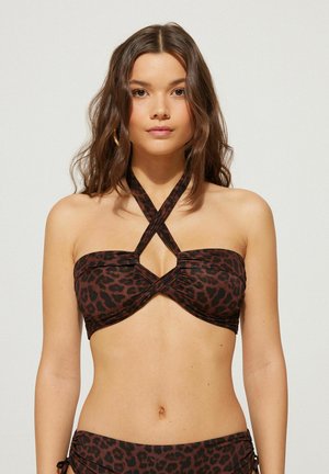 Bralette de bikini con estampado de leopardo negro y marrón, featuring un diseño de cuello halter y tirantes entrecruzados. Tejido suave con detalles fruncidos.