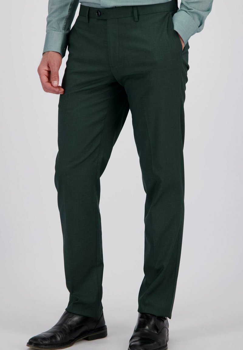 Groene slim fit pantalon gemaakt van een gladde stof, met ingestikte plooien en zijzakken. Draag met zwarte schoenen.