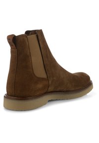 Brun mockaskinn Chelsea-boots med elastiska sidopaneler, rund tå och gummisula. Sömmar med detaljer och en läderdragrem bak.