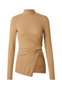Lange mouwen, hoge hals top in lichte bruine ribbelstof. Heeft een gedraaide knoopdetail op de taille en een asymmetrische zoom.