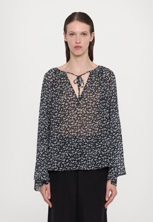 Blusa nera trasparente con un motivo floreale in azzurro chiaro. Presenta un colletto a V con chiusura a fiocco e maniche lunghe e fluenti. Texture morbida.
