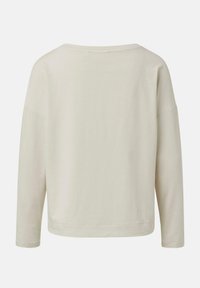 Světle béžový dlouhý rukáv top s širokým, zaobleným límcem a spadlými rameny. Hladká látka, volný střih a rovný spodní lem v pase.