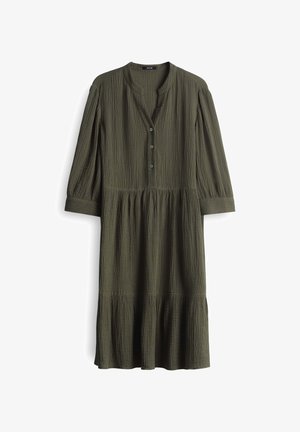 Robe olive verte, longueur genoux, en tissu froissé. Présente un col henley avec trois boutons et des manches froncées. Ourlet évasé.