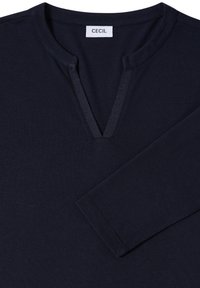 Marineblauw langemouwen shirt met een ondiepe V-hals. Gemaakt van zacht materiaal; bevat een label met de naam "CECIL" nabij de kraag.
