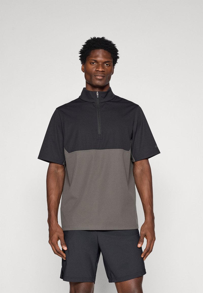 Μαύρη και γκρίζα μπλούζα με κοντό μανίκι και φερμουάρ, κατασκευασμένη από ελαφρύ ύφασμα με λείοι υφή, διαθέτει ψηλό γιακά και σχεδίαση με αντίθετα χρώματα.