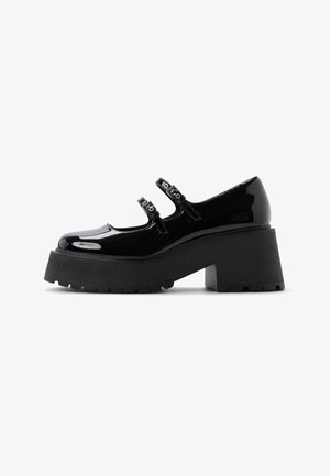 Black patent leather Mary Jane shoe with double buckle straps, thick lug sole, and chunky block heel, side view on white background.