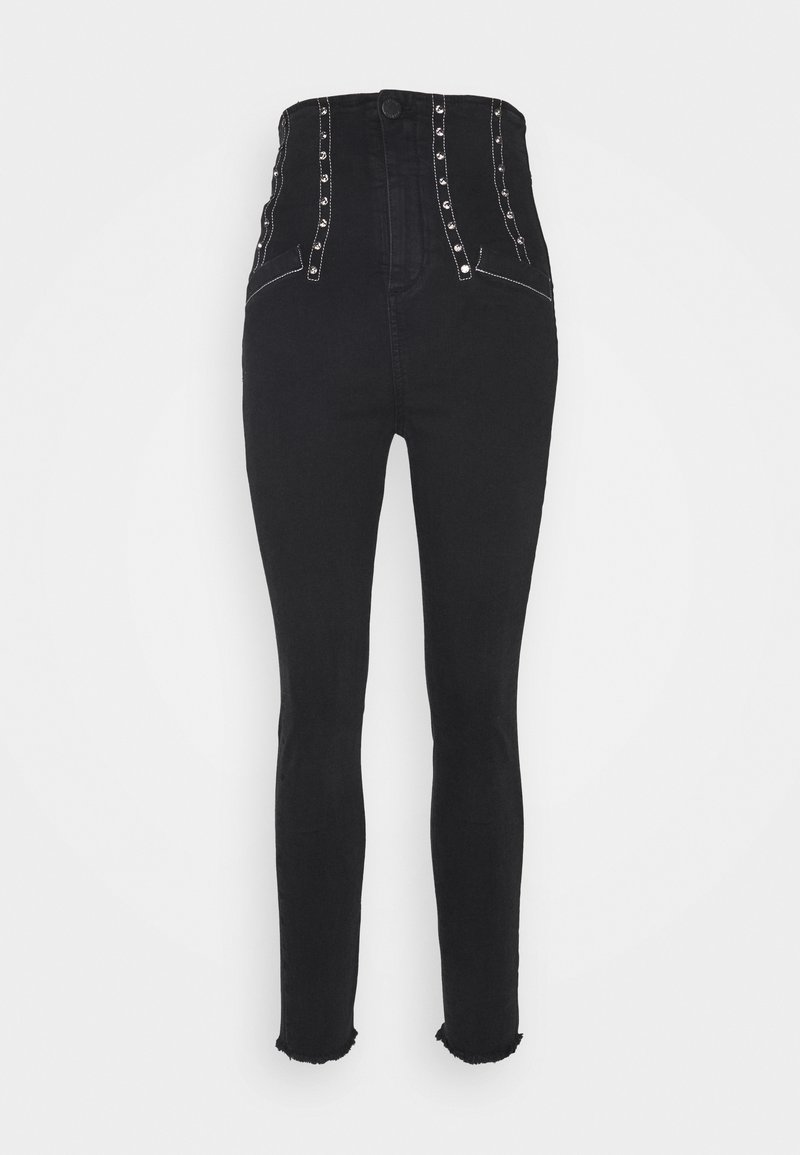 Jeans de mezclilla negros de cintura alta con acentos en botones plateados, detalles laterales y dobladillo deshilachado. Silueta ajustada, diseño minimalista.