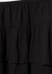 Jupe en tissu noir avec des volants superposés et une taille élastique froncée.