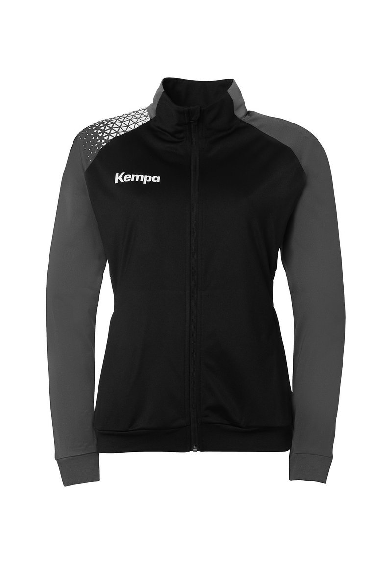 Zwarte jas met grijze mouwen, ritssluiting, hoge kraag en een getextureerd geometrisch patroon op de linkerschouder. Bevat het "Kempa" logo aan de voorkant.
