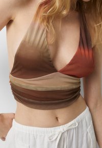 Top corto halter en marrón y óxido, hecho de tela transparente con detalles fruncidos, que presenta un diseño de escote en V y una transición de color degradado.