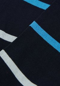 Granatowa dzianina z poziomymi paskami w jasnoniebieskim i białym kolorze. Miękka tekstura z jednolitym wzorem w całej powierzchni.